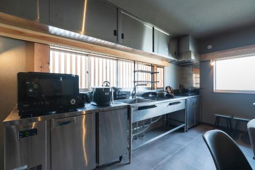 a kitchen with a sink and a counter top at 薪ストーブの古民家一軒宿アゼミチタベネル in Shimo-ayashi