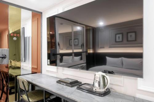 a bedroom with a bed and a mirror on the wall at Yeogieottae Gwangju Baegun branch in Gwangju