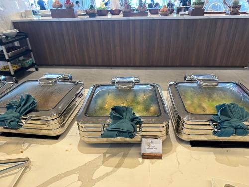 three trays of food on a table in a store at Apec Mandala Mũi Né Sun Sea Condotel in Mui Ne