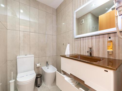 a bathroom with a toilet and a sink and a mirror at Feel Corporate Housing Marquês Garden View in Porto