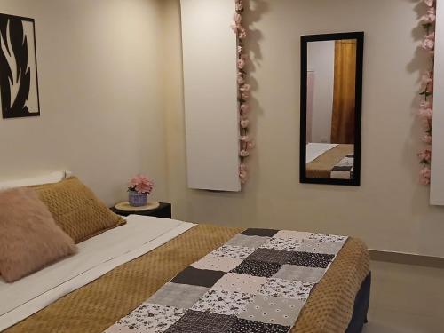 a bedroom with a bed and a mirror on the wall at Yashira Boutique Hotel in Bogotá