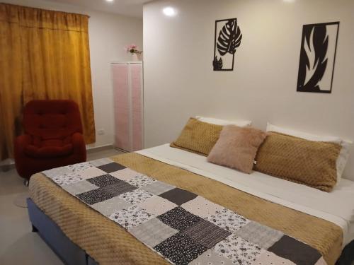 a bedroom with a bed with a quilt and a chair at Yashira Boutique Hotel in Bogotá