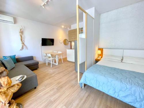 a bedroom with a bed and a couch and a table at Apartment in Porto Santa Margherita by the Sea in Porto Santa Margherita di Caorle