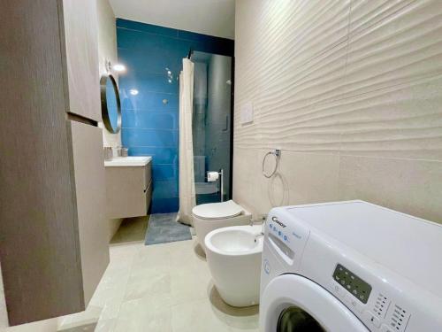 a bathroom with a toilet and a washing machine in it at Apartment in Porto Santa Margherita by the Sea in Porto Santa Margherita di Caorle