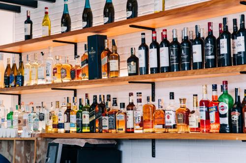 a bar filled with lots of bottles of alcohol at The Mansion Boutique Hotel in Mabalacat