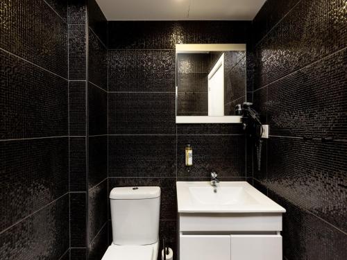 a black tiled bathroom with a toilet and a sink at Feel Porto Wine Essence II in Vila Nova de Gaia