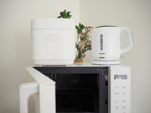 two white appliances sitting on top of a microwave at 池袋駅7分 2-5人丨7 minutes from Ikebukuro Station 2-5 people in Tokyo