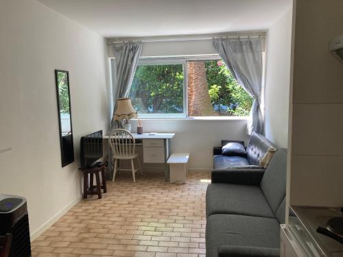 un salon avec un canapé et un bureau dans l'établissement Les clémentines, à Nice