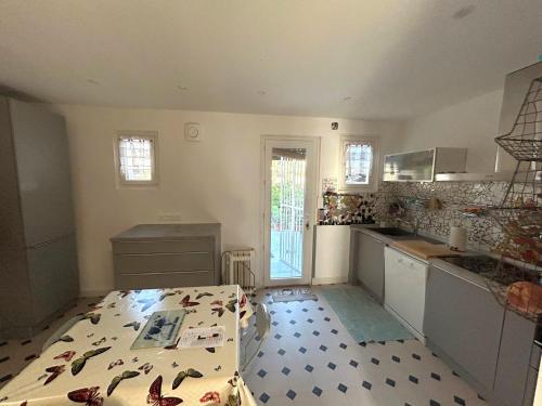 une cuisine avec une table avec des papillons sur le sol dans l'établissement Maison sur 2 étages à 50m de la plage avec jardin - FR-1-837-18, à Argelès-sur-Mer