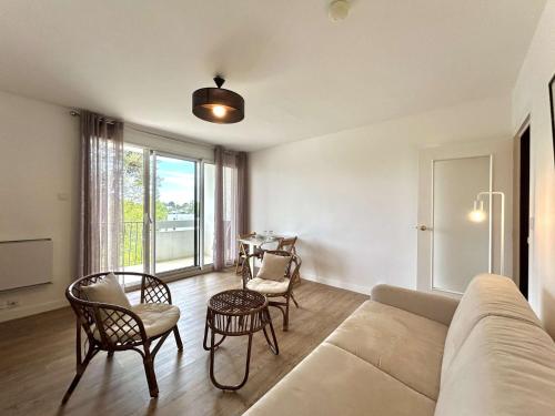 un salon avec un canapé, des chaises et une table dans l'établissement Studio calme face au port de Pouliguen, proche quartier Benoît - FR-1-245-217, au Pouliguen