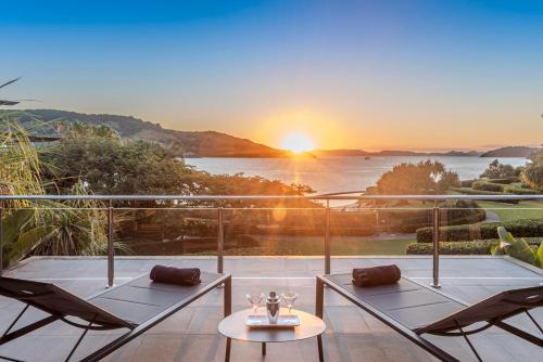 a balcony with a view of the ocean at sunset at Yacht Club Villas on Hamilton Island by HIHA in Hamilton Island