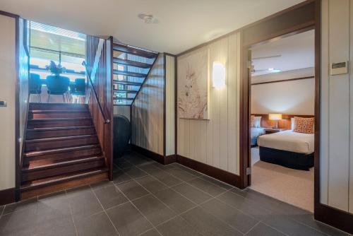 a room with a staircase leading to a bedroom at Yacht Club Villas on Hamilton Island by HIHA in Hamilton Island