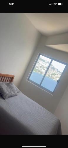 a room with a bed and a window at La Palapa Acapulco in Acapulco
