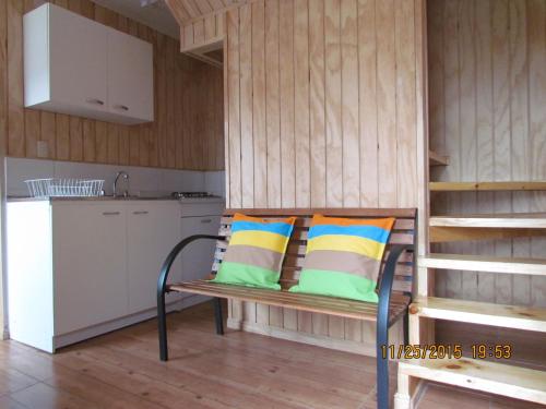 a bench with two pillows on it in a kitchen at Cabañas Entre Parques in Osorno