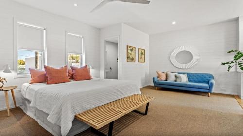 a bedroom with a large bed and a blue couch at Byron Centre Apartment with Pool in Byron Bay