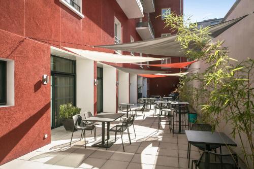 a row of tables and chairs on the side of a building at Comfort Aparthotel Lourdes Lorda in Lourdes