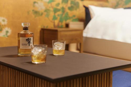 Una botella de whisky y dos vasos en una mesa. en Asakusa Premium Stay 彩-Irodori-, en Tokio