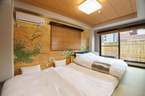 Dos camas en una habitación con un cuadro en la pared. en Asakusa Premium Stay 彩-Irodori-, en Tokio