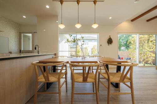 a kitchen with a large wooden table and chairs at New Villa Natural J 伊豆高原 城ヶ崎海岸 in Ito