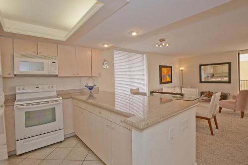 a kitchen with white appliances and a living room at Sea Vista in South Padre Island