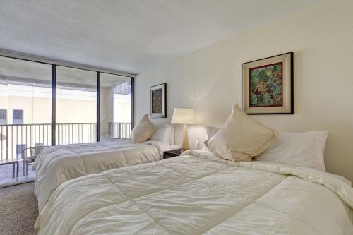 two beds in a room with a balcony at Sea Vista in South Padre Island