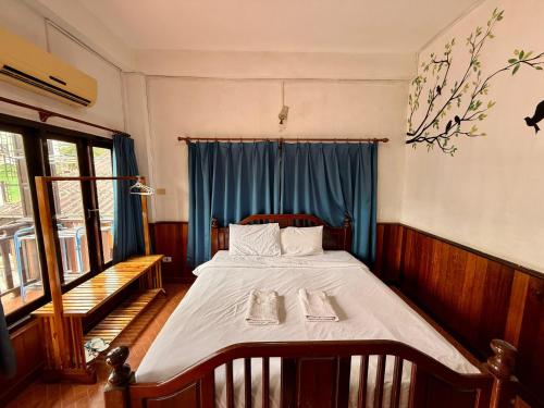 a bedroom with a bed with two towels on it at Domon Riverside Hotel in Vang Vieng