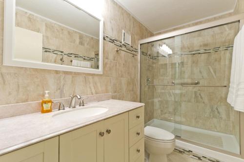 a bathroom with a sink and a toilet and a mirror at Sea Vista in South Padre Island