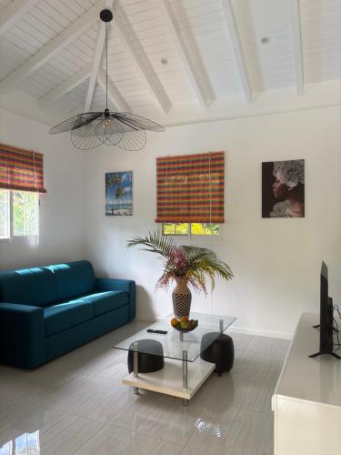a living room with a blue couch and a table at Le Paradis de la Guadeloupe in Pointe-Noire