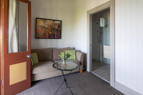 a living room with a couch and a glass table at Q Station in Sydney