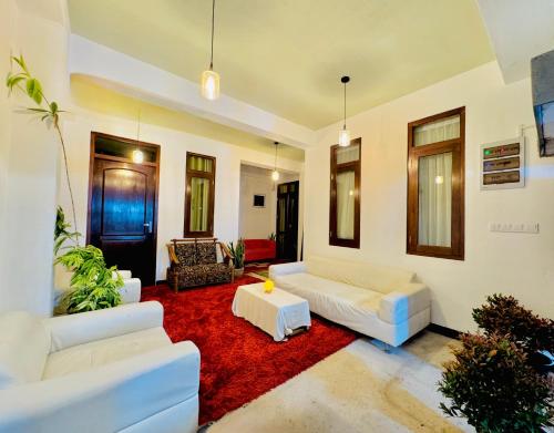 a living room with white couches and a red rug at Sea Breeze Guest House Negombo in Negombo