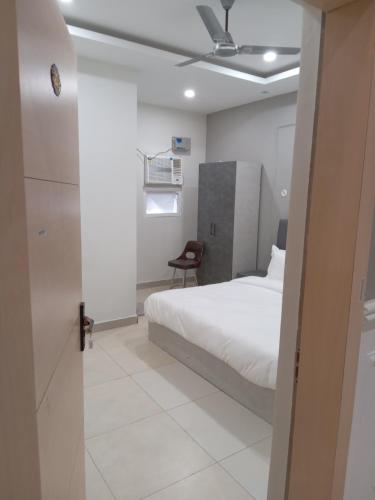 a bedroom with a white bed and a chair at Hotel SS Royal in Lucknow