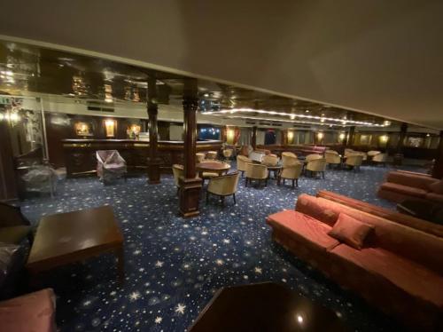 a room with a couch and tables and chairs at nile cruise king boat in Cairo
