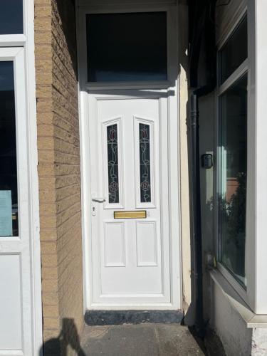 a white door with a window on a building at Stylish and Spacious two-bedroom Apartment in Blackpool