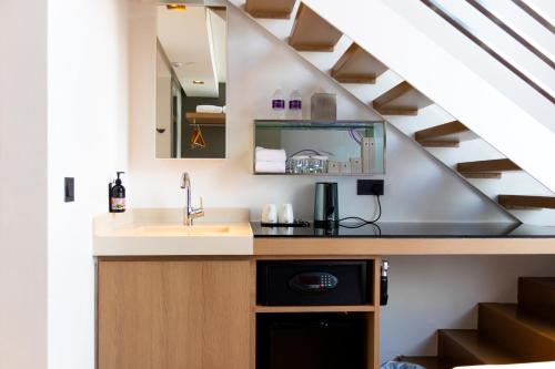 a kitchen with a sink and a staircase at Studio M Hotel in Singapore