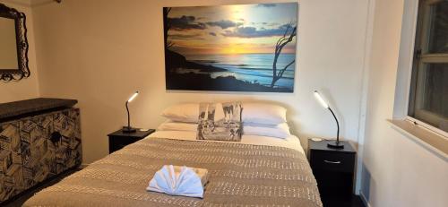 Un dormitorio con una cama y un cuadro en la pared. en G SPOT LOWER LEVEL with spa, en Raglan