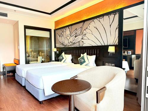 a hotel room with a large bed and a table at Green Dragon Boutique Hotel in Cẩm Phả