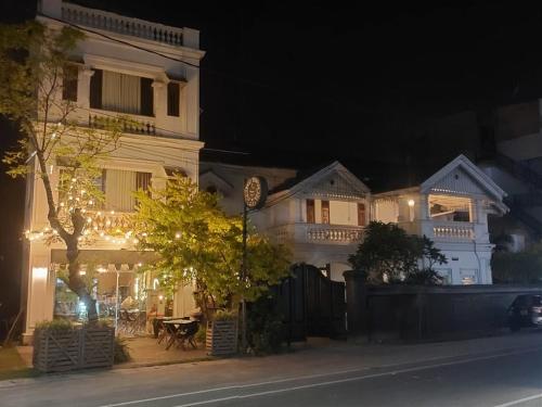 a white house with christmas lights on a street at Villa302 in Galle
