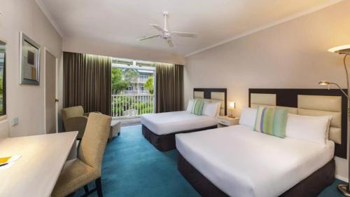 a hotel room with two beds and a desk at Wairakei Resort Taupo in Taupo