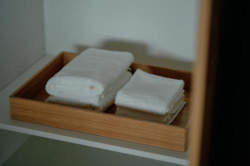a wooden tray with two pieces of white towels at 大洲野田庄旅館 近田屋 in Ōzu