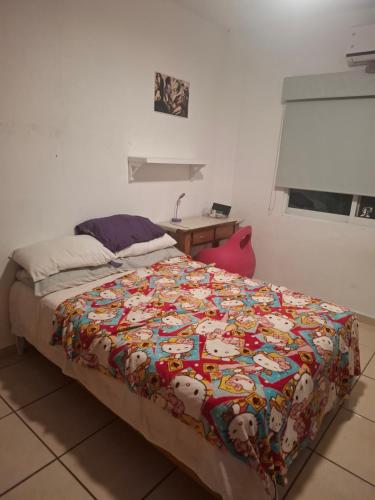 a bedroom with a bed with a colorful comforter at Diana 28 in Jarretadera
