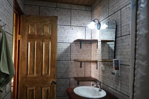 a bathroom with a sink and a white brick wall at Apartamento Siary 1 in Monteverde Costa Rica