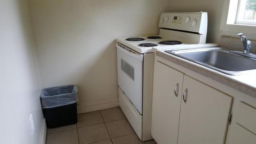 a kitchen with a white stove top oven next to a sink at Pacific Motel in Gridley