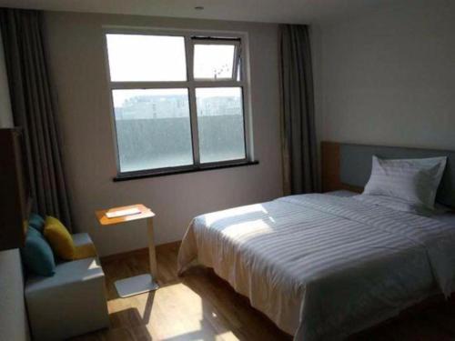 a bedroom with a large bed and a window at 7Days Inn Tianjin Airport NO.1 Bridge Branch in Tianjin