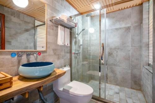 a bathroom with a sink and a toilet and a shower at Longsheng Longji Rice Terraces Jingyue Hotel 龙胜龙脊梯田境悦酒店 in Longsheng