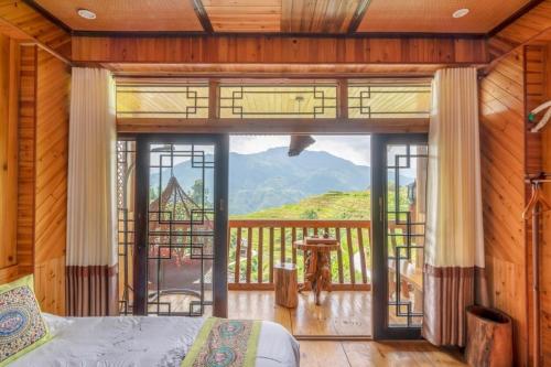 a bedroom with a large window with a view of a mountain at Longsheng Longji Rice Terraces Jingyue Hotel 龙胜龙脊梯田境悦酒店 in Longsheng