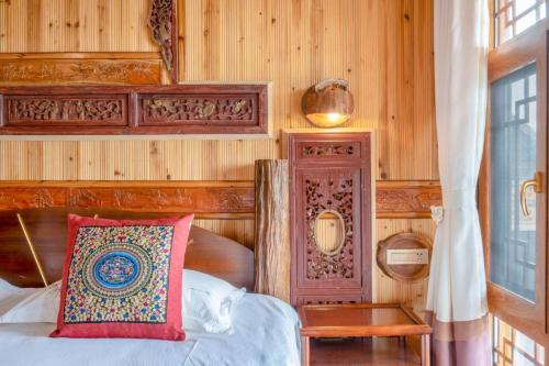 a bedroom with a bed and a wooden wall at Longsheng Longji Rice Terraces Jingyue Hotel 龙胜龙脊梯田境悦酒店 in Longsheng