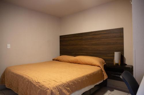 a bedroom with a bed with a wooden headboard at Departamento Carrera in San José de Malpaso