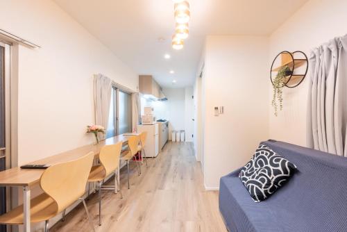 a living room and dining room with a blue couch at 和-羽田 in Tokyo
