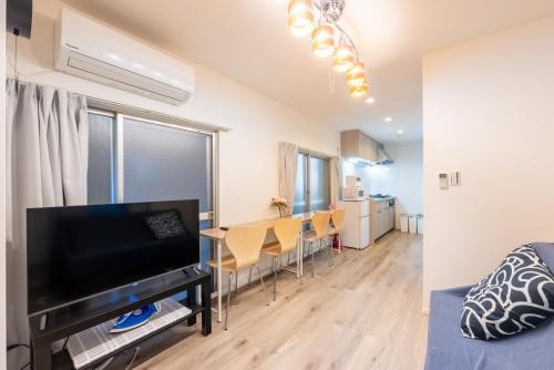 a living room and dining room with a television and a table at 和-羽田 in Tokyo