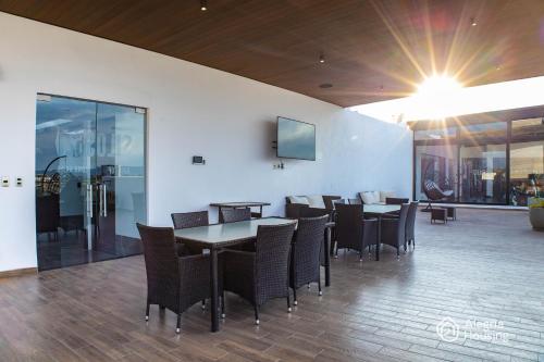 a dining room with tables and chairs and a wall at S- Penthouse Executive Norte - Alegría Housing in Aguascalientes